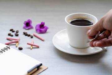 Cup coffee on white textured tile table.