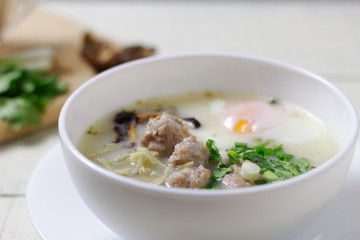 Rice porridge ,congee with minced chicken and Soft-boiled egg in white bowl