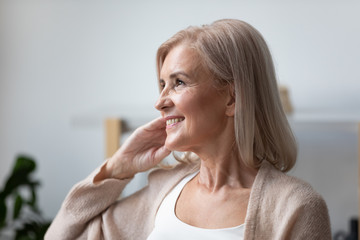 Happy senior woman look in distance dreaming or thinking