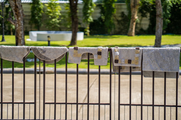 Doormat hanging on metal fence.