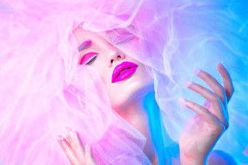 Naklejka na ściany i meble High Fashion art portrait model woman in colorful bright neon lights posing, portrait of beautiful fantasy girl, trendy make-up and colourful tulle hairdo, colorful make up, white skin, Vivid makeup