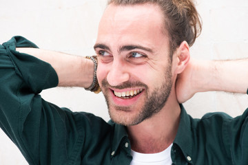 Obraz premium Close up smiling man with beard and hands behind head by white background