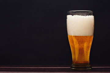 Glass of beer on dark background
