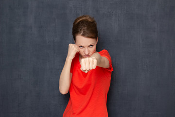 Portrait of enraged dissatisfied girl holding fists clenched