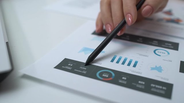 Business woman reading company report, analyzing annual profit, sales statistics
