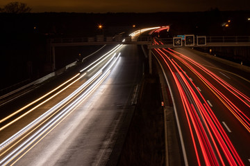 Fototapeta na wymiar Autobahn im Dunkeln, Lichtbänder durch Scheinwerfer, lange Belichtung