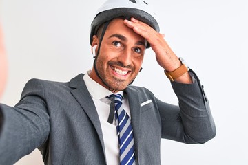 Young handsome business man wearing bike helmet taking a selfie over isolated background stressed with hand on head, shocked with shame and surprise face, angry and frustrated. Fear and upset