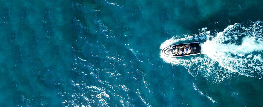 Aerial drone ultra wide photo of jet ski watercraft cruising in high speed in deep blue open ocean sea