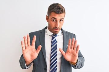 Young handsome business man wearing suit and tie over isolated background Moving away hands palms...