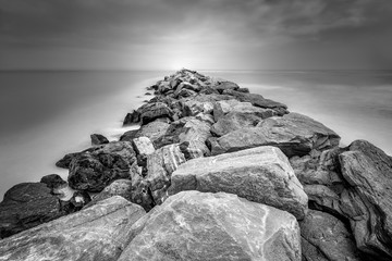Longue exposition noire et blanche d& 39 une jetée rocheuse disparaissant dans l& 39 horizon