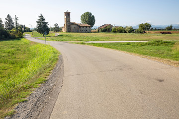 Fototapeta na wymiar paved road and the St Michael the Archangel Church in Montanaro village (San Giorgio Piacentino), Province of Piacenza, Emilia-Romagna region, italy