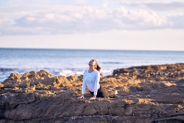 Young beautiful sportwoman practicing yoga. Coach teaching upward-facing dog pose at the beach