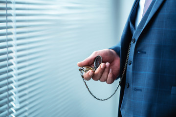 Man is holding and checking his classic pocket watch. Vintage, classic concept . 