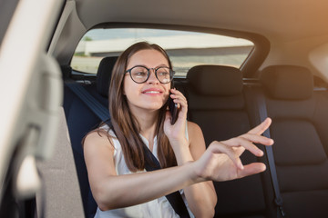 Fototapeta na wymiar Young woman with gadget smartphone sitting in modern car