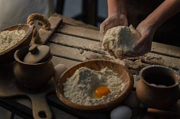 Thin graceful female hands a month dough. Dark Moody.