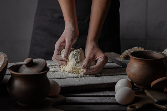 Thin graceful female hands a month dough. Dark Moody. - Powered by Adobe