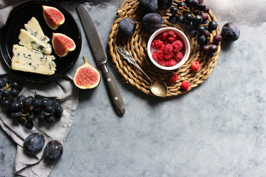Cheese plate with grapes, figs and berry. Wine snaks. Top view with copy space. Flat lay concept.