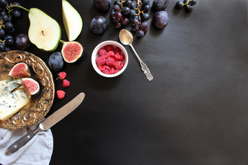 fruits, berries, cheese dor battle. On a black background. Flat lay concept.