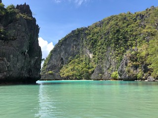 Fototapeta na wymiar clear light blue ocean water on a tropical Asian island with limestone cliffs in the background. El Nido, Palawan, Philippines.
