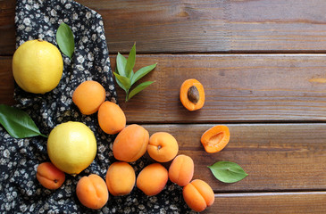 Delicious ripe apricots in a wooden bowl on the table close-up. Flat lay concept.