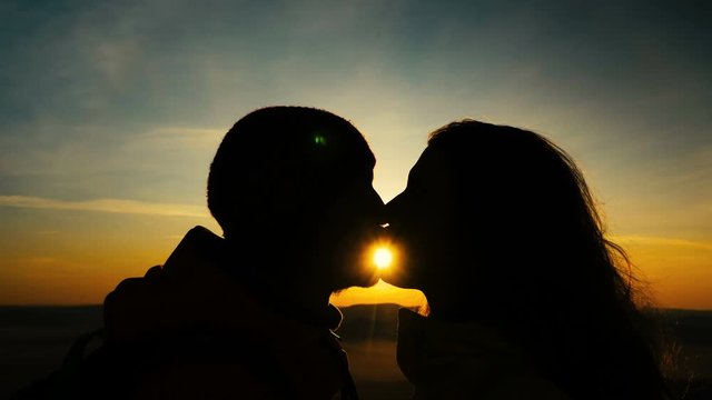 bearded man and long haired lady silhouettes kiss and laugh