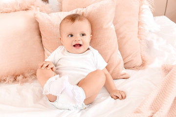 Portrait of cute little baby on bed at home