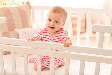 Portrait of cute little baby in crib at home