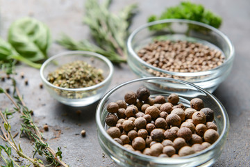 Bowls with different spices on grey background