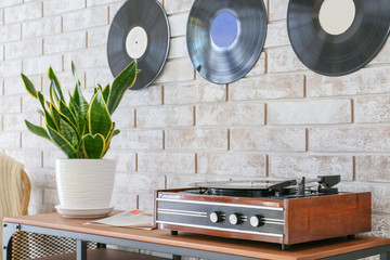 Record player with vinyl disc on table in room