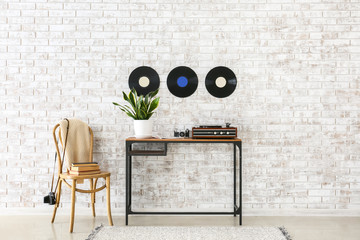 Record player with vinyl disc on table in interior of room