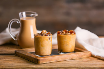 Glasses of tasty cold coffee on wooden table