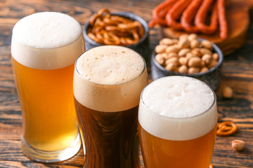 Glasses of different tasty beer on wooden table, closeup
