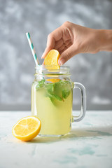 Woman preparing tasty healthy lemonade
