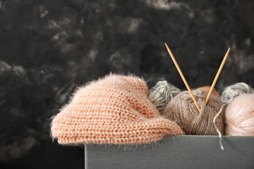 Knitting yarn with needles in box on dark background