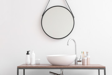 Body care cosmetics with accessories near sink in bathroom