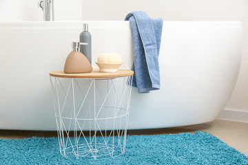 Body care cosmetics with bast wisp on table in bathroom