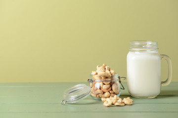 Jar of cashew milk on color background