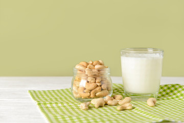 Glass of cashew milk on white table