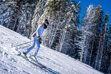 Young woman skiing in mountain ski resort during winter vacation
