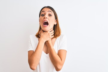 Beautiful redhead woman wearing casual white t-shirt over isolated background shouting and suffocate because painful strangle. Health problem. Asphyxiate and suicide concept.