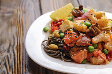 Tasty soba pasta with seafood and vegetables on wooden table