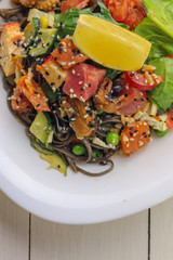 Tasty soba pasta with seafood and vegetables on wooden table