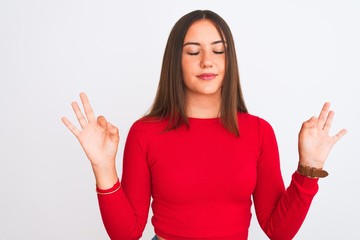 Young beautiful girl wearing red casual t-shirt standing over isolated white background relax and smiling with eyes closed doing meditation gesture with fingers. Yoga concept.