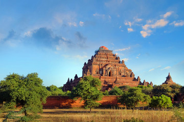 Blue sky above temples surrounded by green vegetation in old Bagan, Myanmar. - obrazy, fototapety, plakaty