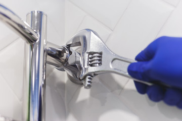 Amateur novice plumber uses the wrong pipe wrench for a heated towel rail in a bathroom home