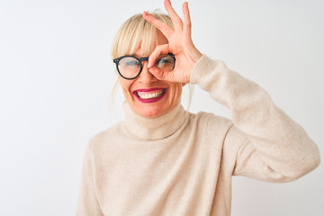 Middle age woman wearing turtleneck sweater and glasses over isolated white background doing ok...
