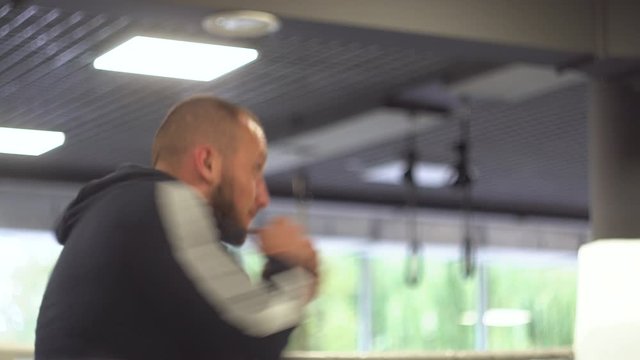 A man making strikes at fight training. Young muscular athlete fulfills kick