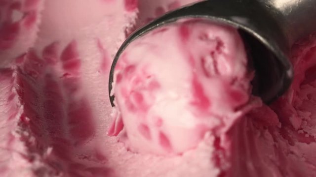 Ice cream flavoured Strawberry scooped out from container with a spoon, Closeup Front view Food concept.