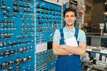 Plumber at showcase with valves and pipe adapters