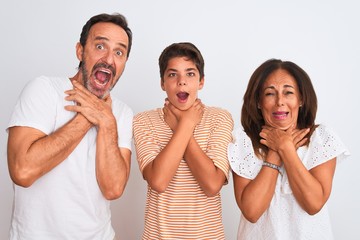 Family of three, mother, father and son standing over white isolated background shouting and suffocate because painful strangle. Health problem. Asphyxiate and suicide concept.